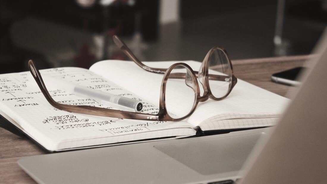 A pair of glasses on a notebook representing a great business idea